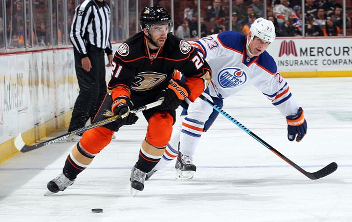 Kyle Palmieri #21 of the Anaheim Ducks handles the puck against Matt Hendricks #23 of the Edmonton Oilers on December 10, 2014 at Honda Center in Anaheim, California.