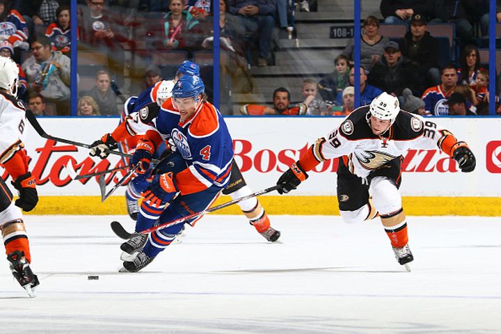Taylor Hall #4 of the Edmonton Oilers skates with the puck as he is pursued by Matt Beleskey #39 of the Anaheim Ducks on December 12, 2014 at Rexall Place in Edmonton, Alberta, Canada.