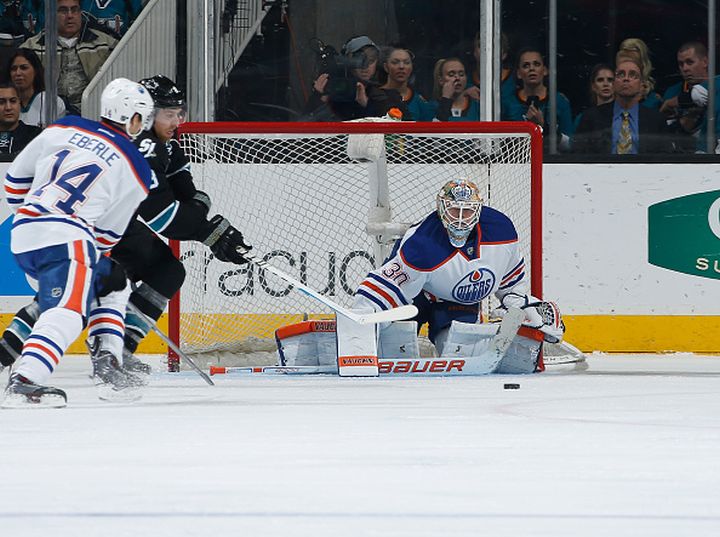  Joe Pavelski #8 of the San Jose Sharks tries to score against Ben Scrivens #30 of the Edmonton Oilers during an NHL game on December 18, 2014 at SAP Center in San Jose, California.