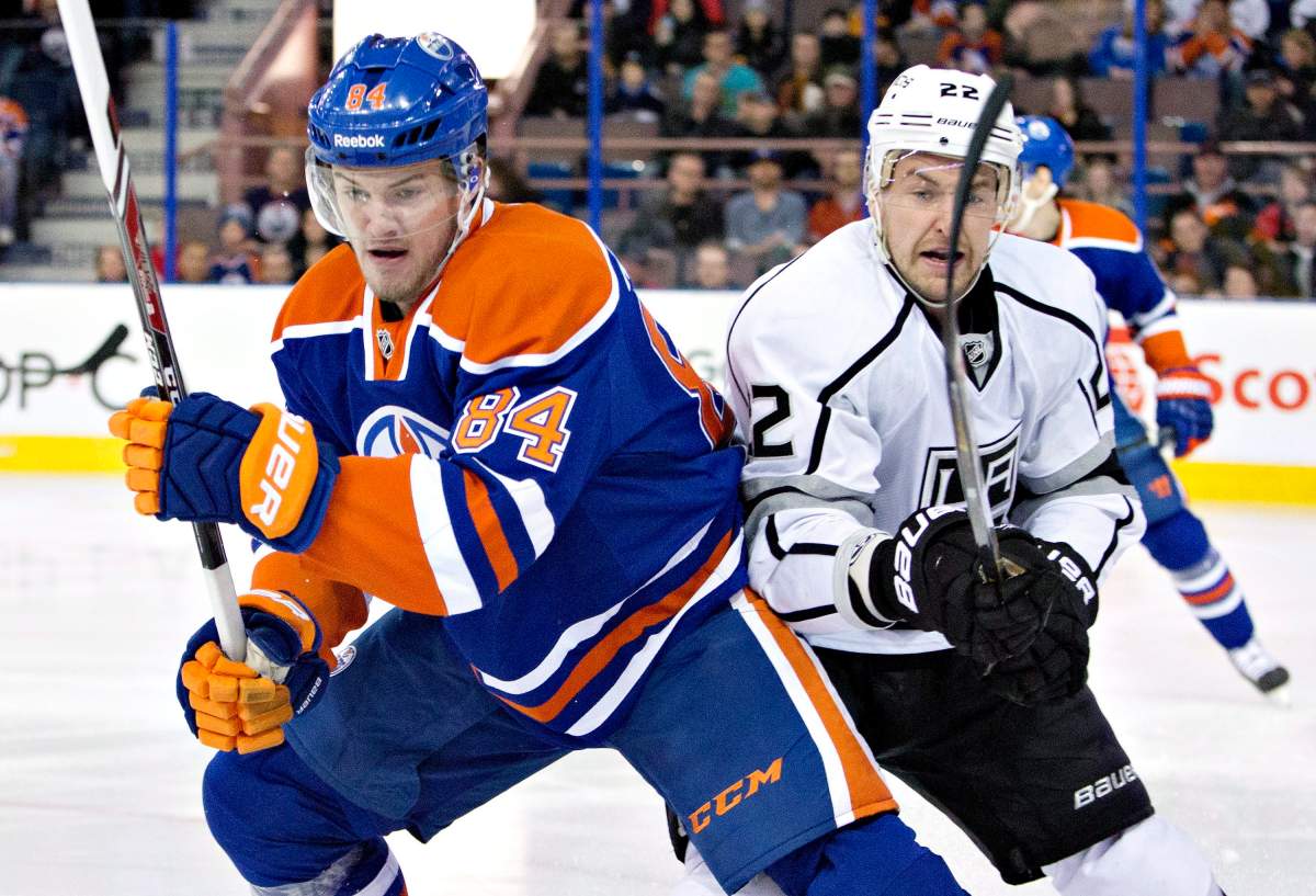 Los Angeles Kings’ Trevor Lewis (22) and Edmonton Oilers’ Oscar Klefbom (84) battle for the puck during first period NHL hockey action in Edmonton, Alta., on Tuesday December 30, 2014.