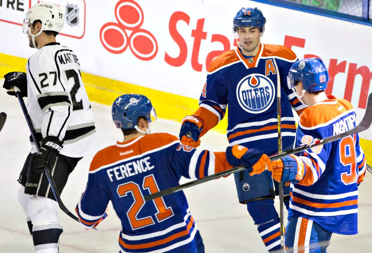 Los Angeles Kings’ Alec Martinez (27) skates past as Edmonton Oilers’ Andrew Ference (21), Ryan Nugent-Hopkins (93) and Jordan Eberle (14) celebrate a goal during second period NHL hockey action in Edmonton, Alta., on Tuesday December 30, 2014.