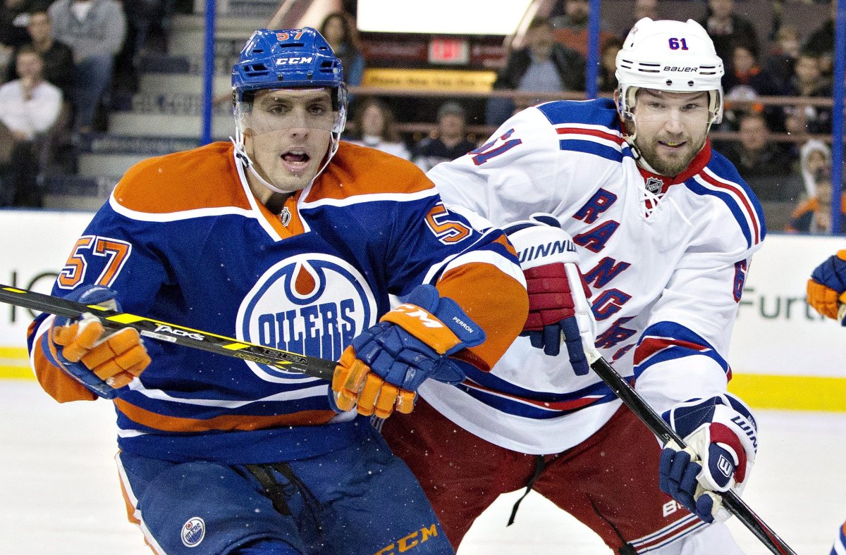 New York Rangers' Rick Nash (61) and Edmonton Oilers' David Perron (57) battle for the puck during first period NHL hockey action in Edmonton, Alta., on Sunday December 14, 2014. 
