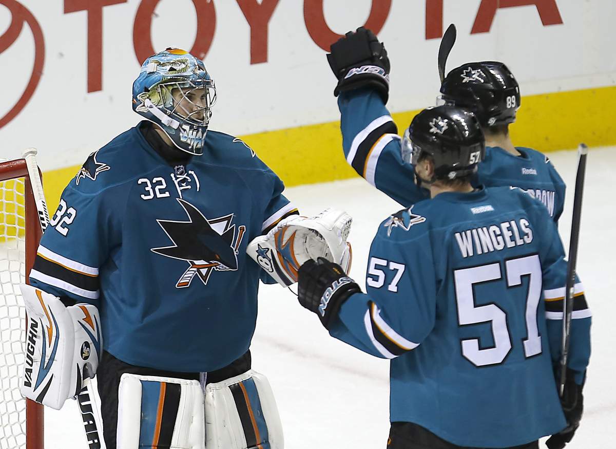 San Jose Sharks goalie Alex Stalock (32) is congratulated by teammates Barclay Goodrow (89) and Tommy Wingels (57) after a 5-2 victory against the Edmonton Oilers in an NHL hockey game Tuesday, Dec. 9, 2014, in San Jose, Calif. 
