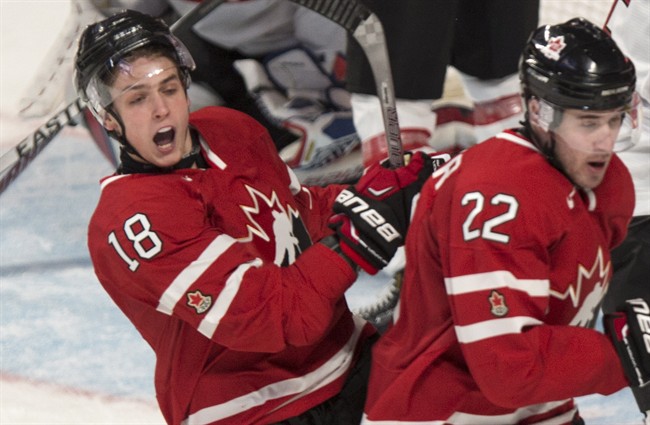 Team Canada's Jake Virtanen, left, celebrates his goal past Team Switzerland goaltender Ludovic Waeber next to teammate Frederik Gauthier during second period exhibition hockey action in preparation for the upcoming IIHF World Junior Championships Tuesday, December 23, 2014 in Montreal.