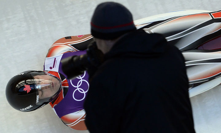 A photographer shoots an image of Canada's Sam Edney during a practices run at the men's Luge training session at the Sanki Sliding Centre in Rosa Khutor on February 6, 2014.   