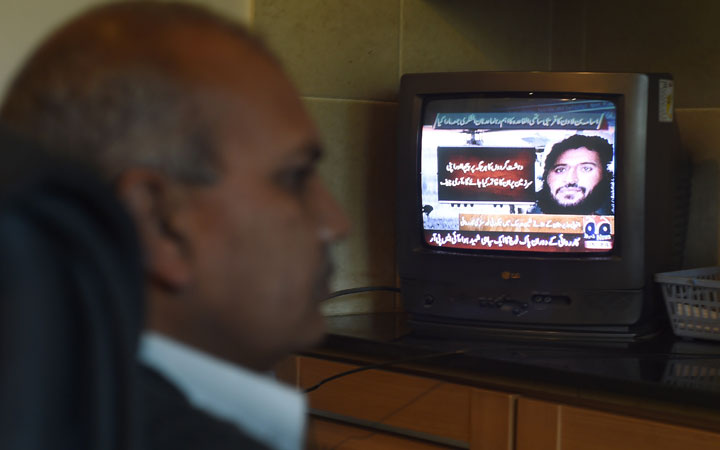 A Pakistani man watches a television broadcasting news of top Al-Qaeda leader Adnan El Shukrijumah, in Islamabad on December 6, 2014.  Pakistan's military said it had killed Shukrijumah, a senior Al-Qaeda leader wanted by the US over a 2009 plot to attack the New York subway system. 
