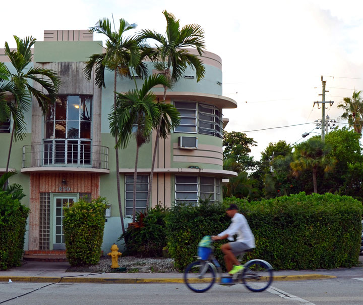 This Nov. 16, 2014 photo shows a man on a rental Citi Bike riding past an example of Art Deco architecture in Miami Beach. Taking a scenic route by bike or on foot through the side streets of South Beach opens up a whole new neighborhood with local haunts that offer high-class cultural experiences at a low-key, friendly pace.