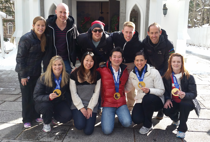 Team Jennifer Jones and Team Kevin Koe pose with hotel owner Nakatsu and his wife in Japan. Jill Officer, in white, is beside Nakatsu, in red and wearing one of their Olympic gold medals.