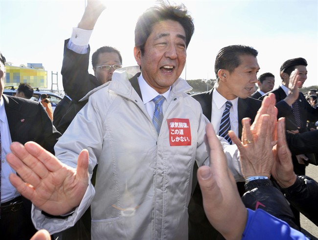 Japanese Prime Minister Shinzo Abe of the ruling Liberal Democratic Party greets the crowd in Soma, Fukushima, northeastern Japan, Tuesday, Dec. 2, 2014, on the first day of official campaigning for this month's elections. (AP Photo/Kyodo News) .