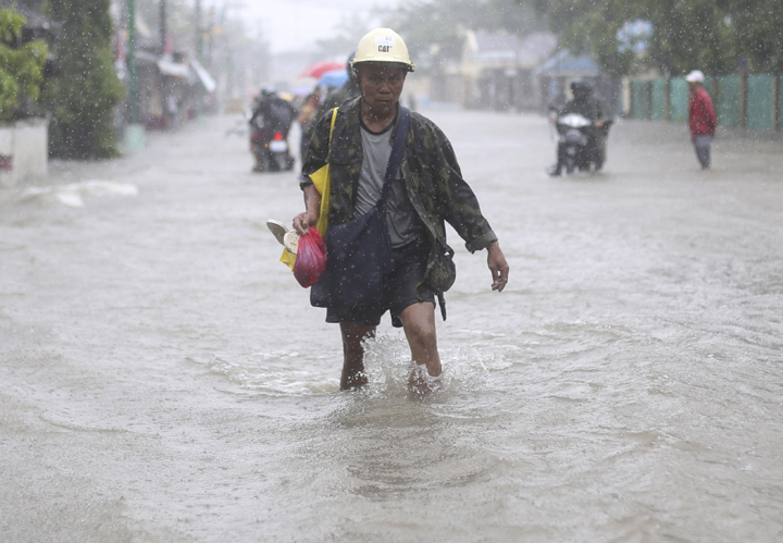 A resident wades in floodwaters bought by Typhoon Hagupit in Camarines Sur province, eastern Philippines Monday, Dec. 8, 2014. 