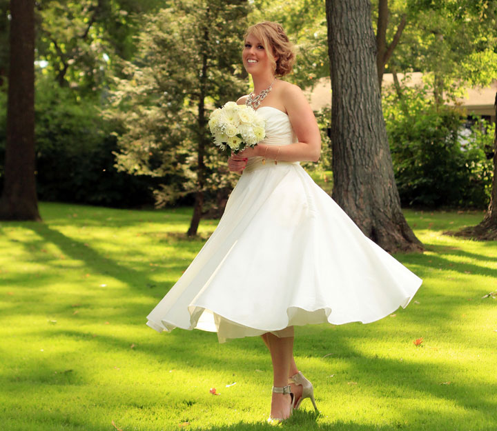 In this Sept. 20, 2014 photo released by Alan D. Charles, Helen Bradley, 27, of DePere, Wis., poses on her wedding day at a country club in Madison, Wis. She chose a short gown for three reasons: comfort, affordability and the chance to show off her accessories.
