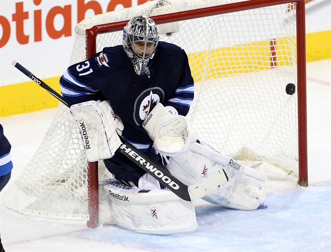 Winnipeg Jets goaltender Ondrej Pavelec (31) is scored on by Anaheim Ducks' Kyle Palmieri, not shown, during overtime NHL hockey action in Winnipeg, Sunday, December 7, 2014.