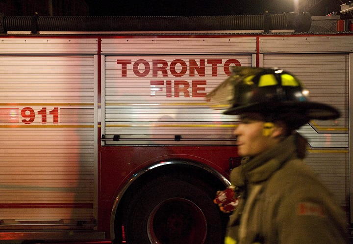 A Toronto firefighter walks past a fire truck at the scene of a fire at the Black Bull Restaurant on Queen St. West and John Street in Toronto, April 21, 2011. 
