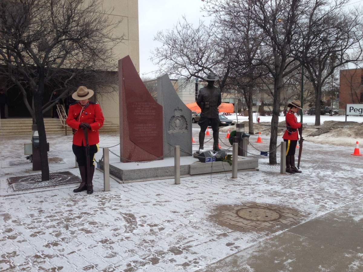 At D Division in Winnipeg, RCMP members bow their heads on Jan. 26, 2015.