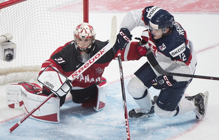Canadian goaltender Zach Fucale pushes Slovakia's Dominik Rehak from his crease during second period preliminary round hockey action at the IIHF World Junior Championship in Montreal, Friday, December 26, 2014.