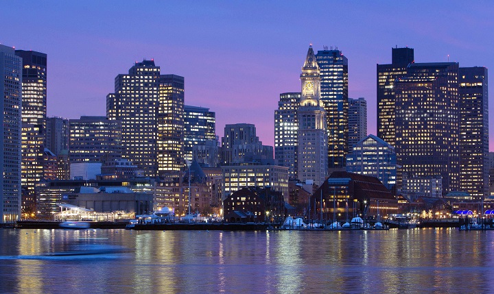 In this Jan. 6, 2012 file photo, the Boston city skyline is illuminated at dusk as it reflects off the waters of Boston Harbor. 
