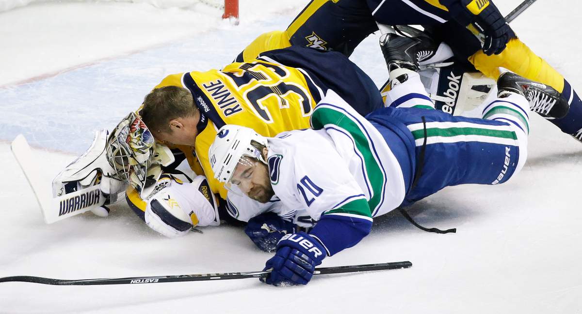 Vancouver Canucks left wing Chris Higgins (20) collides with Nashville Predators goalie Pekka Rinne (35), of Finland, in the first period of an NHL hockey game Tuesday, Jan. 13, 2015, in Nashville, Tenn. Higgins was called for goaltender interference. 