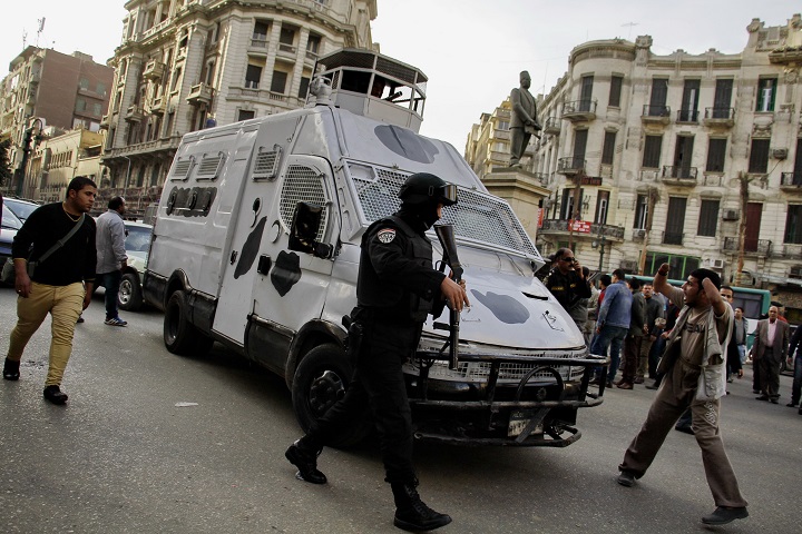 A member of the Egyptian security forces disperses people gathering to protest against a court order to release the two sons of ousted Egyptian President Hosni Mubarak in Talaat Harb Square downtown Cairo, Egypt, Thursday, Jan. 22, 2015. 