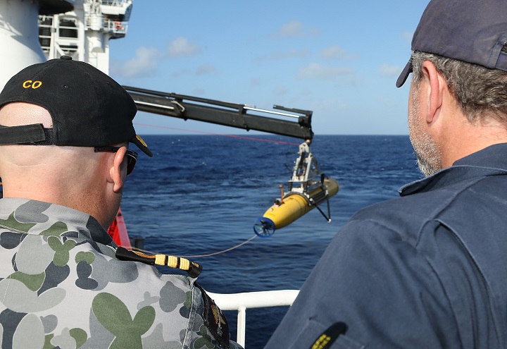 In this handout image provided by Commonwealth of Australia, Department of Defence, Commander James Lybrand Mission Commander ADV Ocean Shield (L)and Chris "Sharkie" Moore, Phoenix Team Lead, watch the launching the Phoenix Autonomous Underwater Vehicle (AUV) Artemis off the deck of ADV Ocean Shield on April 17, 2014. 