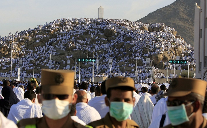 Saudi police secure the street as Muslim pilgrims pray on a rocky hill called the Mountain of Mercy, on the Plain of Arafat near Mecca, Saudi Arabia, Sunday, Dec. 7, 2008.