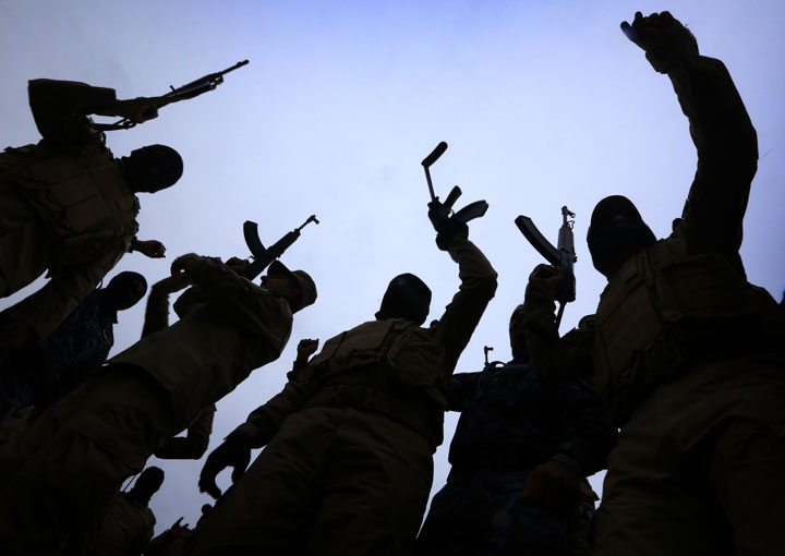 Iraqi policemen raise their weapons during a training session at a camp in the Bardarash district, 30 kilometres northeast of Mosul in January 2015. The policemen were preparing to try and drive IS out of Mosul.