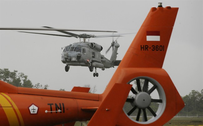A U.S. Navy helicopter approaches to land following their search operation for the victims of AirAsia Flight 8501at the airport in Pangkalan Bun, Indonesia, Tuesday, Jan. 6, 2015. 