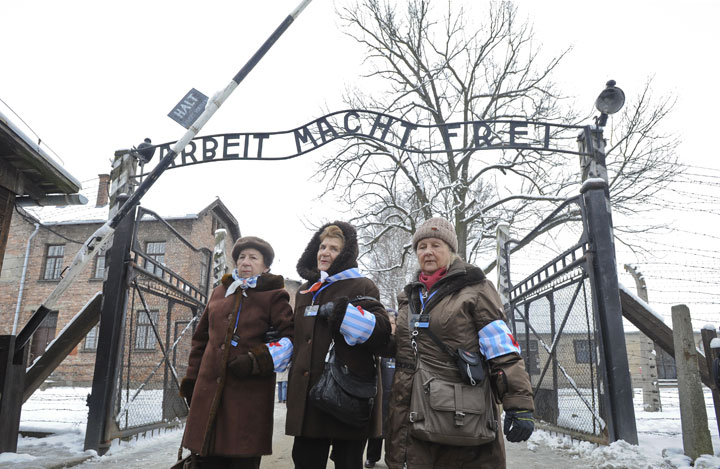 Holocaust survivors walk outside the gate of the of the Auschwitz Nazi death camp in Oswiecim, Poland, Tuesday, Jan. 27, 2015. 