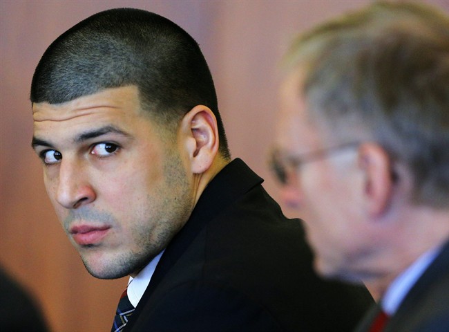 FILE - In this Dec. 22, 2014 file photo, former New England Patriots tight end Aaron Hernandez, left, attends a pretrial hearing in Fall River, Mass. 