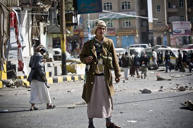 In this Tuesday, Jan. 20, 2015 file photo, Houthi Shiite Yemenis gather while guarding a street leading to the presidential palace in Sanaa, Yemen. 