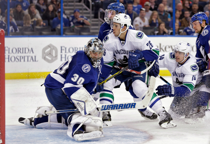 Vancouver Canucks defenseman Frank Corrado (26) watches the puck go past Tampa Bay Lightning goalie Ben Bishop (30) for a goal during the third period of an NHL hockey game Tuesday, Jan. 20, 2015, in Tampa, Fla. The Lightning won 4-1. 