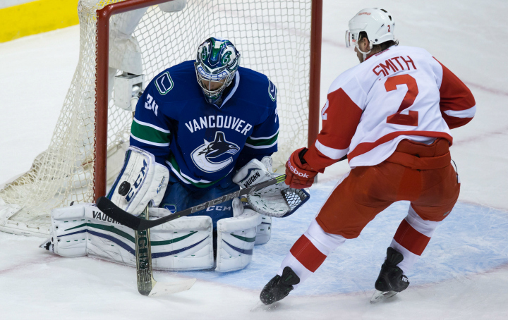 Vancouver Canucks goalie Ryan Miller, left, stops Detroit Red Wings' Brendan Smith during second period NHL action in Vancouver on Saturday January 3, 2015. 