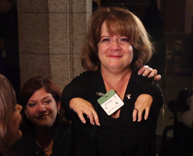 An emotional Mercedes Benegbi who is a thalidomide survivor and executive director of the Thalidomide Victims Association of Canada, celebrates on Parliament Hill after the House of Commons voted to compensate survivors of thalidomide, in Ottawa on Monday, December 1, 2014. The federal government is offering a $125,000 lump sum payment to thalidomide victims.