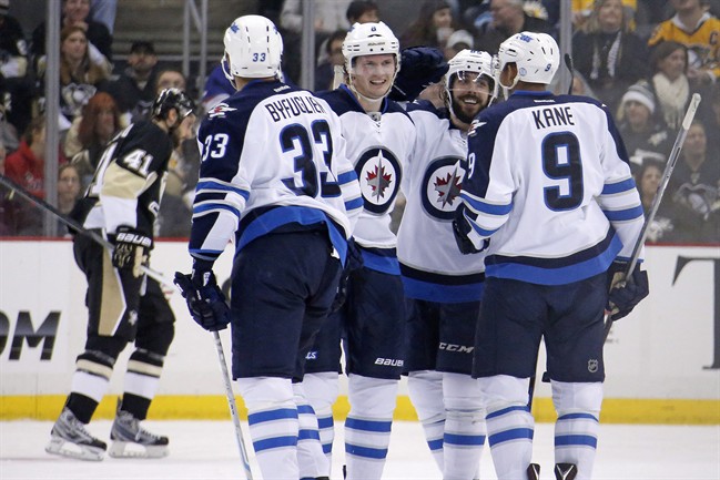 Winnipeg Jets' Jacob Trouba, second from left in front, celebrates his goal with teammates during the second period of an NHL hockey game against the Pittsburgh Penguins in Pittsburgh on Jan. 27, 2015.