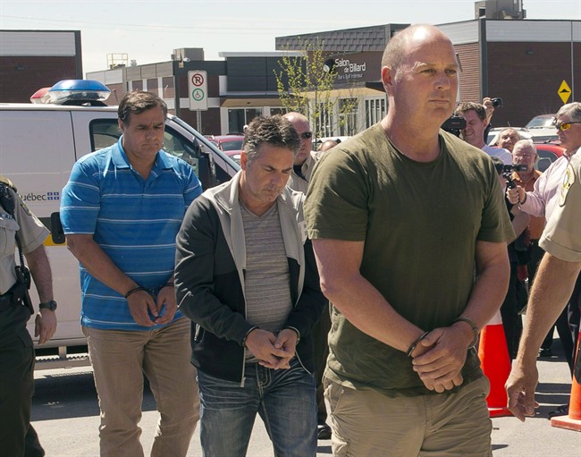 Former Montreal Maine and Atlantic Railway Ltd. employees Tom Harding, right, Jean Demaitre, centre, and Richard Labrie are escorted by police to appear in court in Lac-Megantic, Que., on Tuesday, May 13, 2014. 