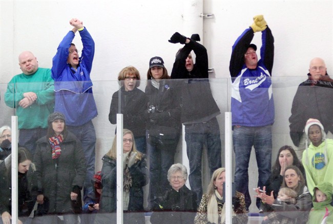 Hockey parents react to a call during a game in St. Louis Park, Minn. Friday, March 1, 2013. A British Columbia minor hockey league is threatening to ban spectators if parents and other observers don't start minding their manners.