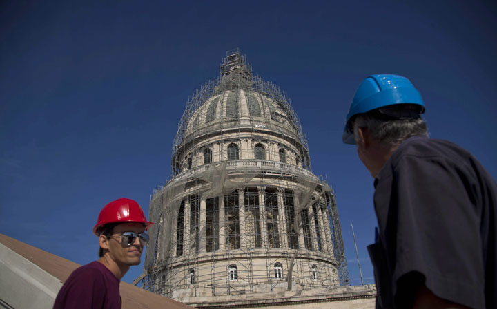 This Dec. 30, 2014 photo shows construction workers outside the Capitol dome under restoration in Havana, Cuba. 