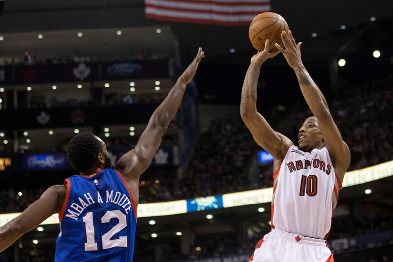 Toronto Raptors' DeMar DeRozan (right) shoots on Philadelphia 76ers' Luc Mbah a Moute during second half NBA basketball action in Toronto on Wednesday, January 14, 2015. 