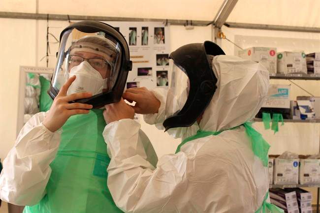 Members of the Operation SIRONA Task Force dress in protective equipment at the Kerry Town Treatment Unit in Sierra Leone, Jan.9, 2015.