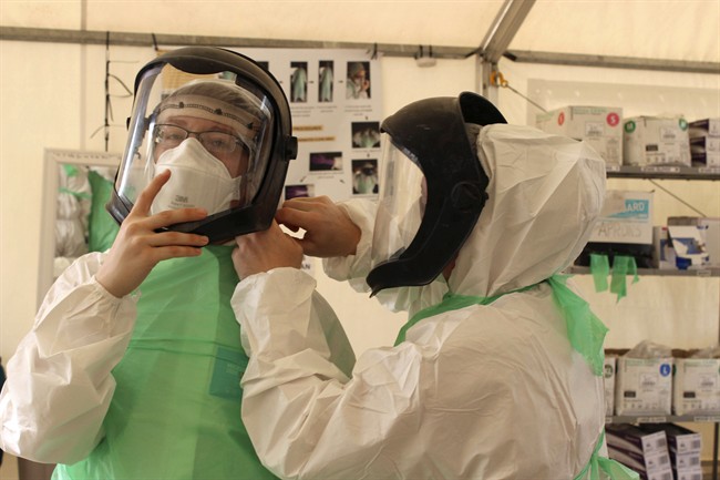 Members of the Operation SIRONA Task Force dress in protective equipment at the Kerry Town Treatment Unit in Sierra Leone, Jan.9, 2015.