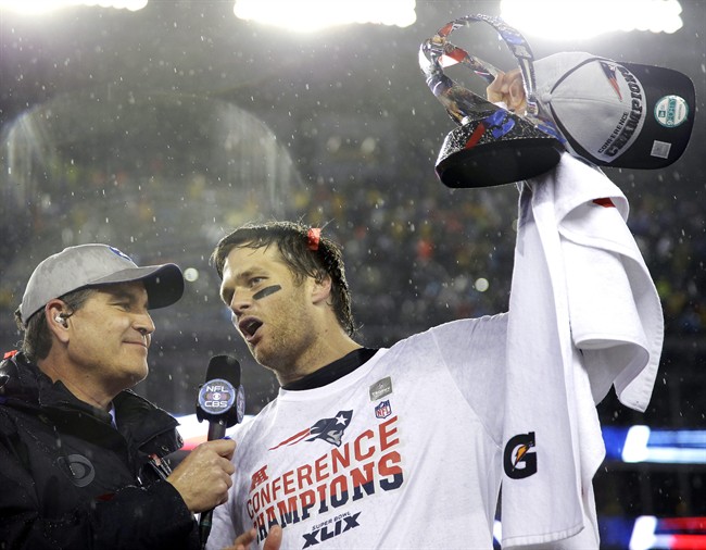 New England Patriots quarterback Tom Brady, right, holds the championship trophy while being interviewed by Jim Nance after the NFL football AFC Championship game Sunday, Jan. 18, 2015,