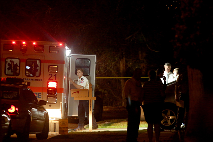In this photo taken Wednesday, Jan. 21, 2015, an ambulane is parked as investigators gather outside an East Lake, Fla., home, where authorities say a two-year-old child died from an apparent self-inflicted gunshot wound.