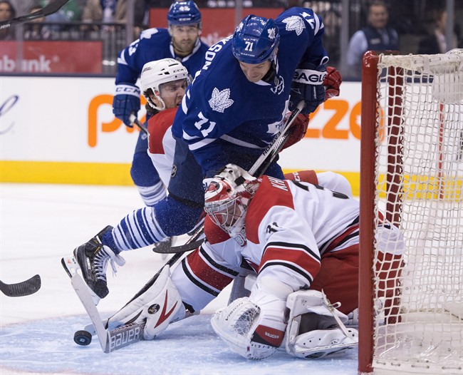 Carolina Hurricanes goaltender Anton Khudobin makes a save on Toronto Maple Leafs right winger David Clarkson (71) as he is hauled down by Hurricanes defenceman Bret Bellemore (73) during second period NHL action in Toronto on Monday, January 19, 2015. 