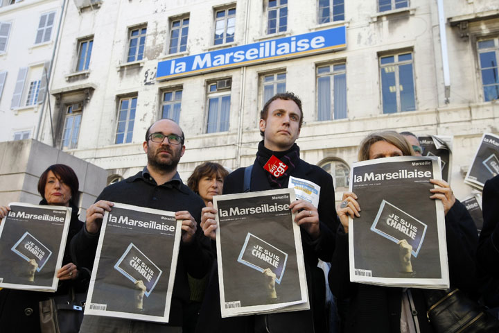 Employees and journalists of the newspaper “La Marseillaise” hold a journal of the day, reading” I am Charlie” , in front of the newspaper building during a minute of silence , in Marseille, southern France, Thursday, Jan. 8, 2015.