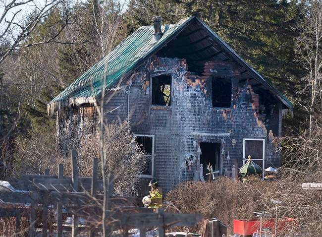 A firefighter works at the scene of a fatal house fire near Wyses Corner, N.S., outside of Halifax, on Thursday, Jan. 8, 2015. 