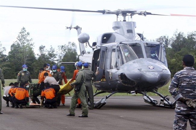 Indonesian military personnel unload the bodies believed to be the victims of AirAsia Flight 8501 from a helicopter at Iskandar Airport in Pangkalan Bun, Central Borneo, Indonesia, Thursday, Jan. 22, 2015. 