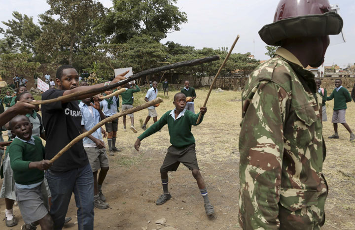 Kenyan school pupils and activists challenge riot police during a protest against the removal of their school's playground, at the Langata Road Primary School, in Nairobi, Kenya Monday, Jan. 19, 2015. 