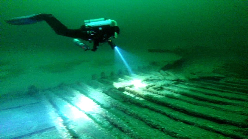 This image taken from video shows diver Andrew Driver swimming over part of a 19th-century canal boat that lies on the floor of Lake Ontario's eastern end near Oswego, N.Y. Jim Kennard, Roger Pawlowski, and Roland Steven, three underwater explorers from the Rochester area, said, Wednesday, Jan. 21, 2015.