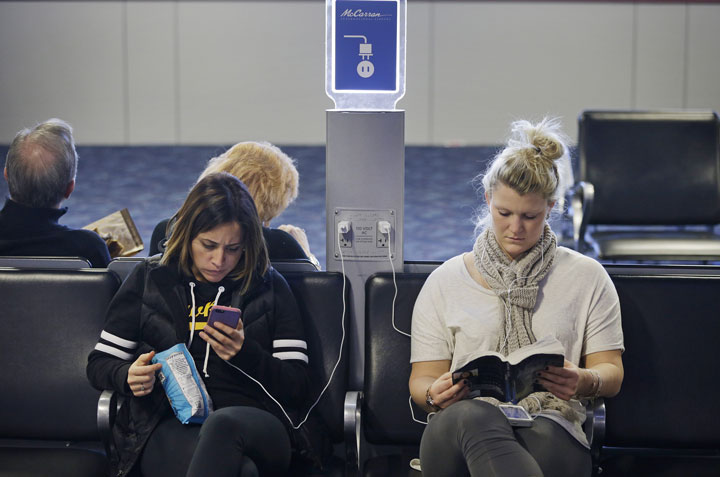Travellers use a charging station at McCarran International Airport in Las Vegas in December 2014.