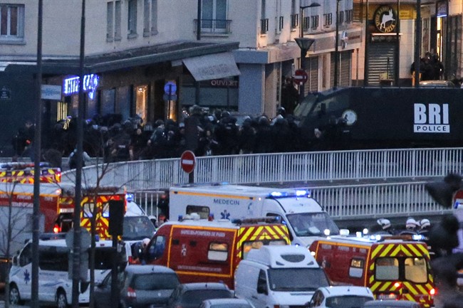 This is a Friday Jan. 9, 2015 file photo of police officers as they storm the kosher market where a gunman held several hostages, in Paris. 