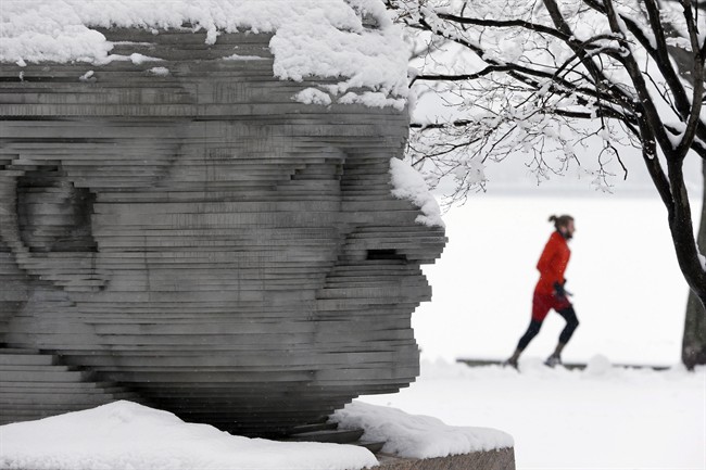 A jogger passes a statue of Arthur Fiedler on the Esplanade in Boston, Saturday, Jan. 24, 2015. (AP Photo/Michael Dwyer).